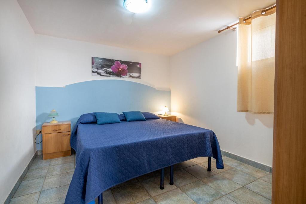 - une chambre avec un lit bleu et une couverture bleue dans l'établissement Sun Beach Villa, à Marina di Mancaversa