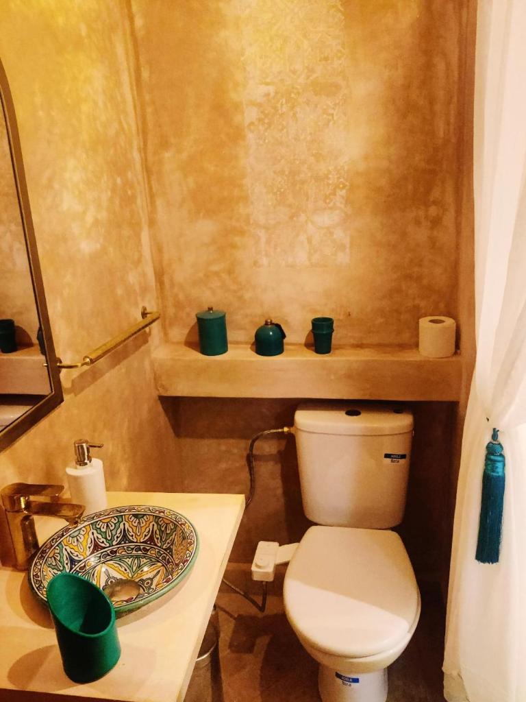 une salle de bain avec des toilettes et une assiette sur une table dans l'établissement Riad Nirvana, à Marrakech