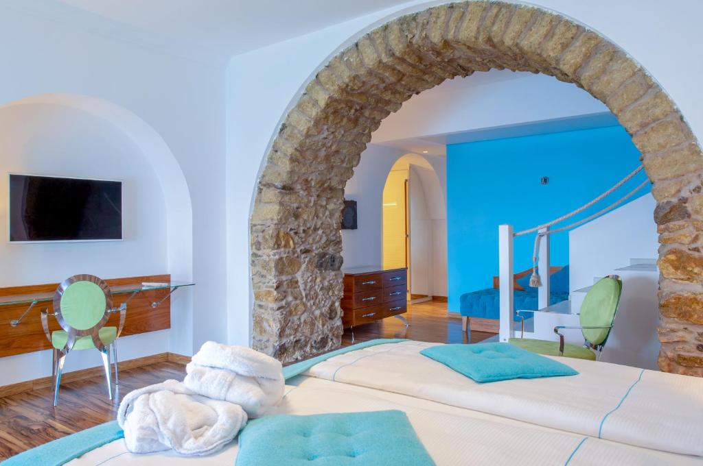 - une chambre avec un grand lit et une arche en pierre dans l'établissement Piccolo Grand Hotel, à Pizzo