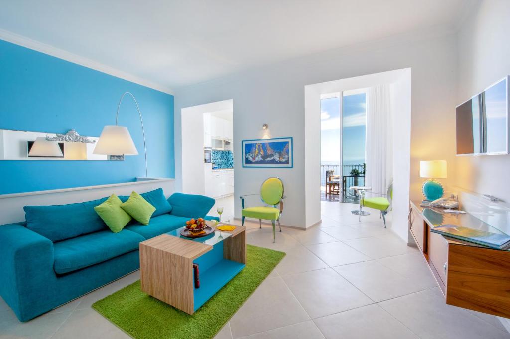 un salon avec un canapé bleu et une table dans l'établissement Piccolo Grand Hotel, à Pizzo