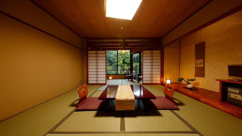 une pièce avec une table, des chaises et une fenêtre dans l'établissement Yanagawa Hakuryuso, à Yanagawa