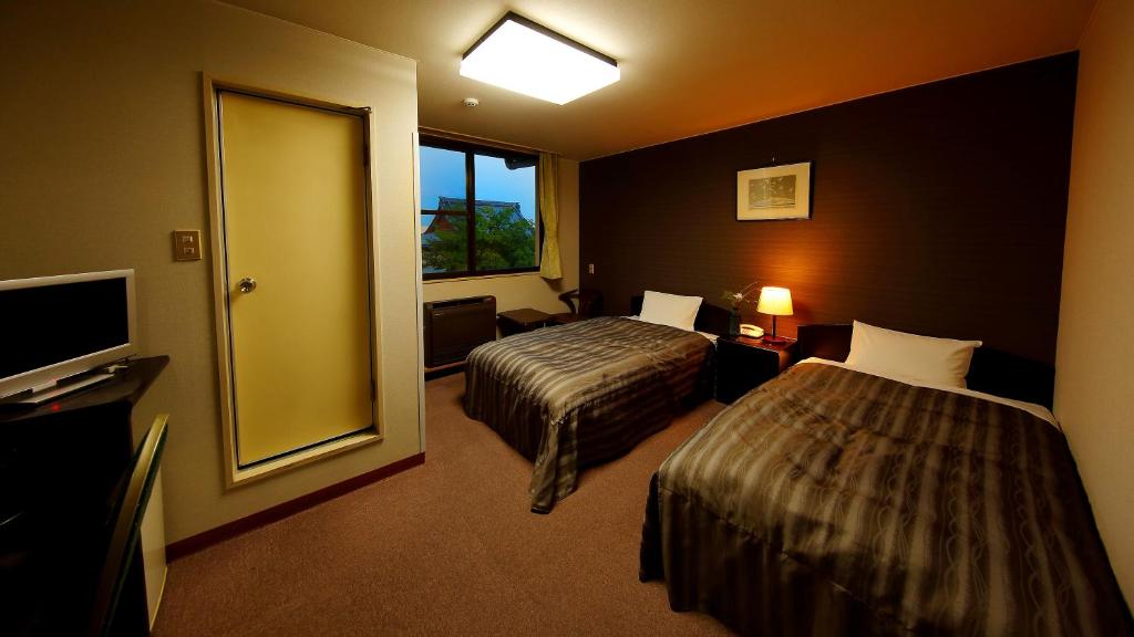 une chambre d'hôtel avec deux lits et une télévision dans l'établissement Yanagawa Hakuryuso, à Yanagawa 21 autres photos