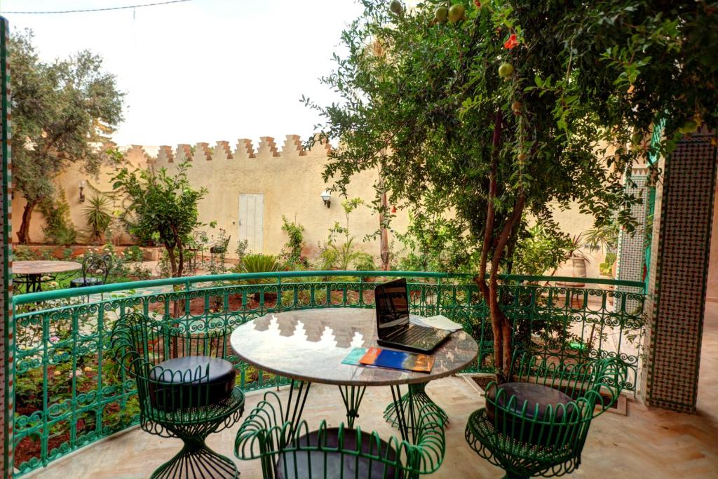 d'une terrasse avec une table, des chaises et un ordinateur portable. dans l'établissement Riad Dar Ziryab, à Fès