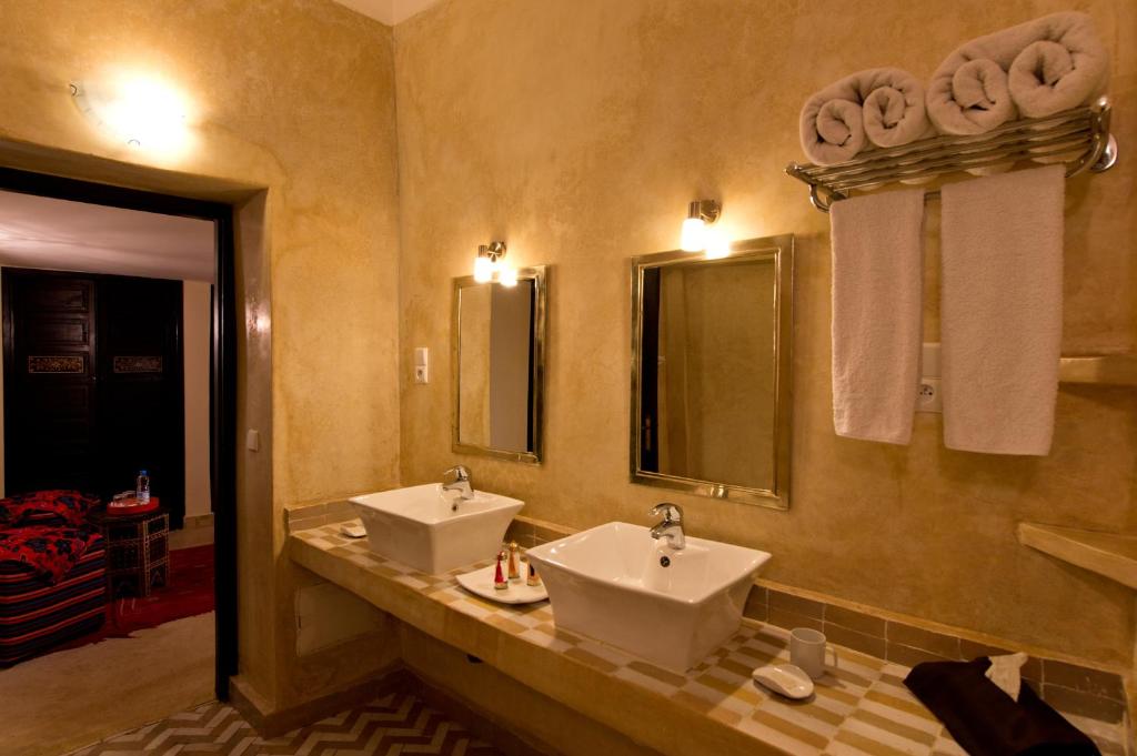 une salle de bain avec deux lavabos et deux miroirs dans l'établissement Riad Signature, à Marrakech