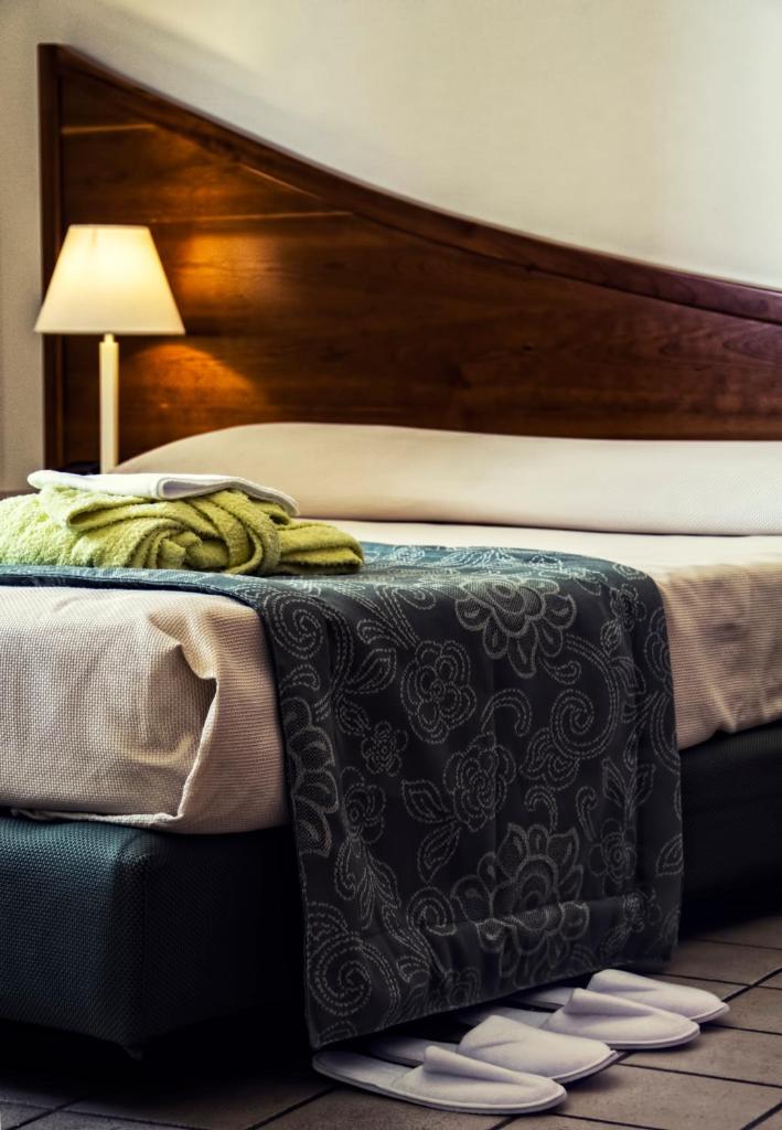 - un lit avec une couverture noire et blanche et une lampe dans l'établissement Hotel Sirenetta, à Isola delle Femmine