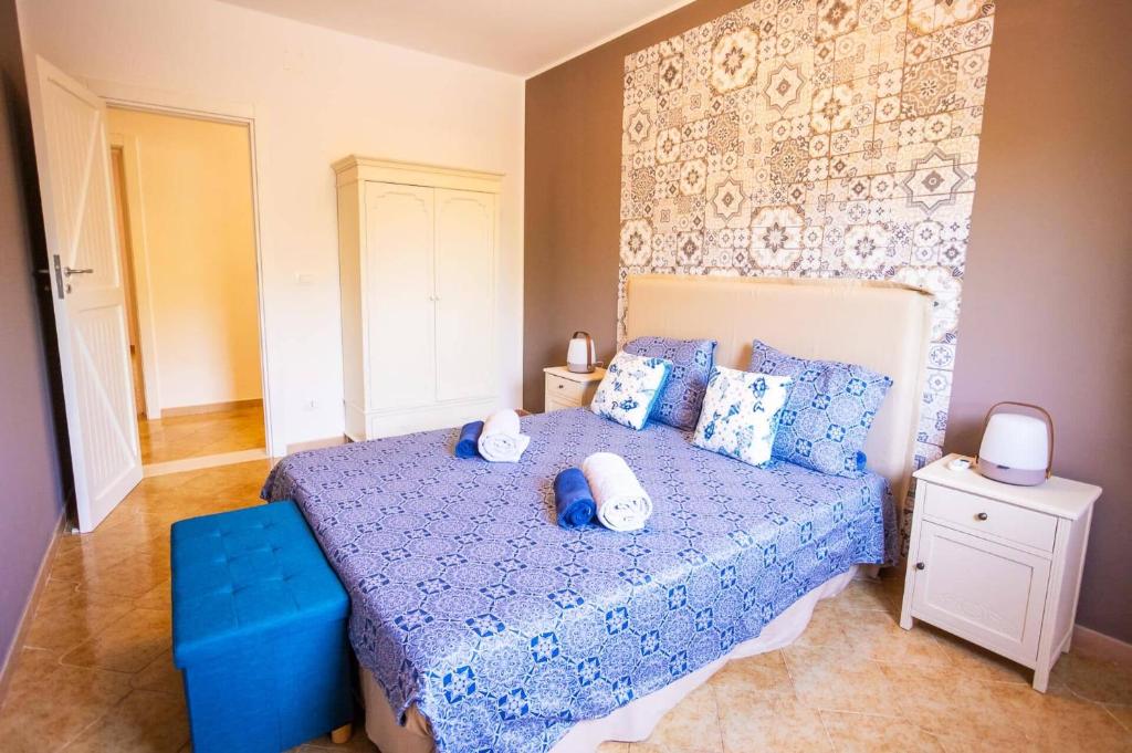 - une chambre avec un lit bleu et des oreillers dans l'établissement Villa Olivier by Villa Plus, à Carovigno 16 autres photos