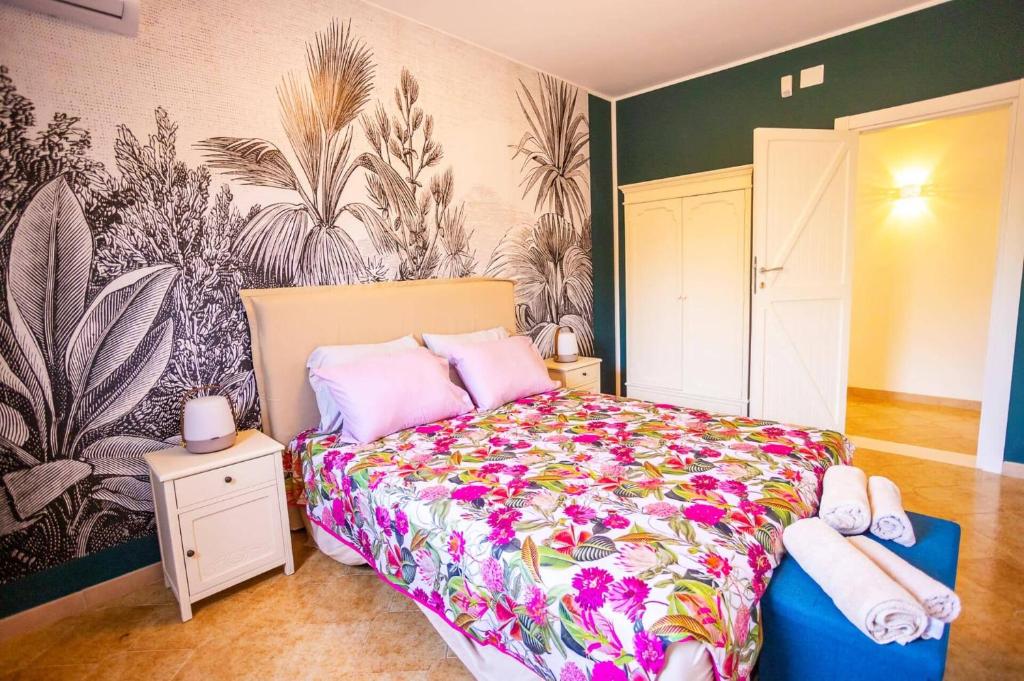 une chambre avec un grand lit avec un couvre-lit fleuri dans l'établissement Villa Olivier by Villa Plus, à Carovigno