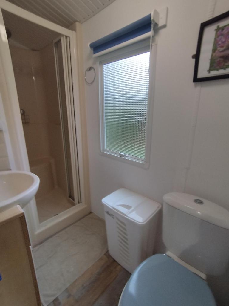 une salle de bain avec toilettes, lavabo et fenêtre dans l'établissement camping proche du Touquet, à Camiers 4 autres photos