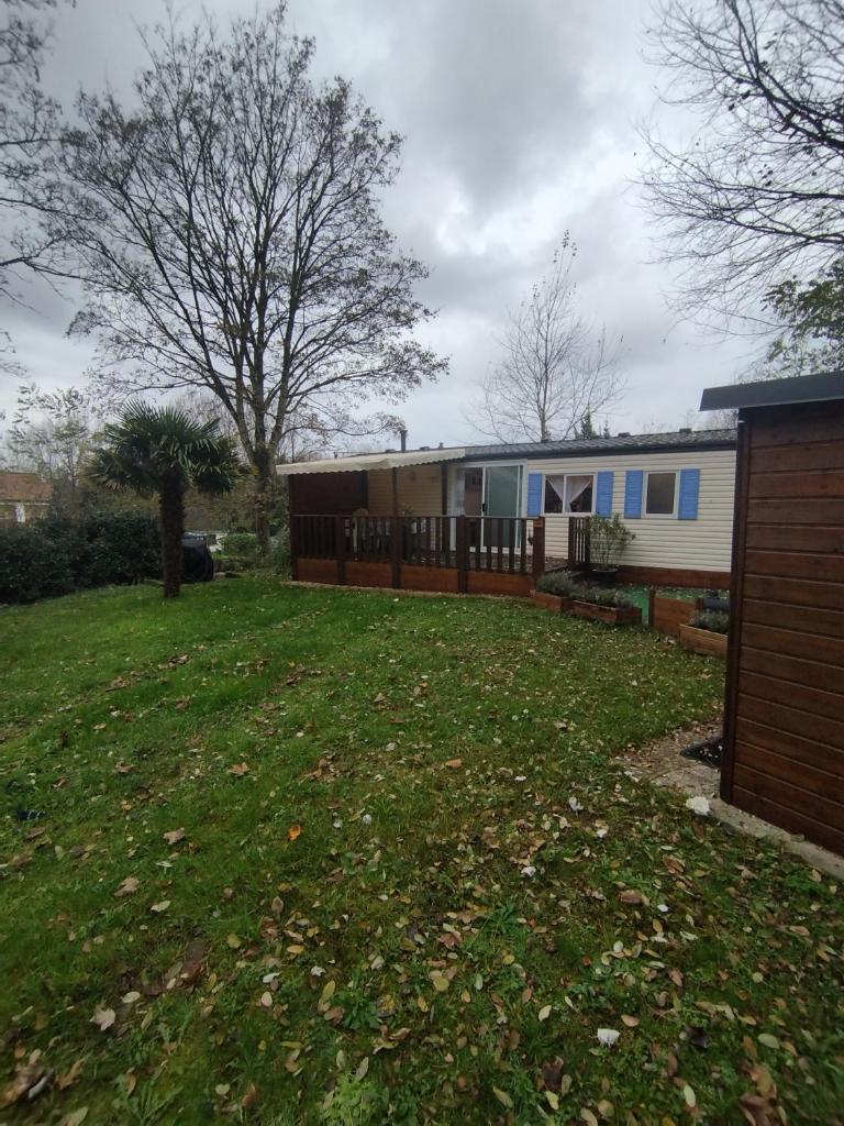 une cour avec une clôture et une maison dans l'établissement camping proche du Touquet, à Camiers