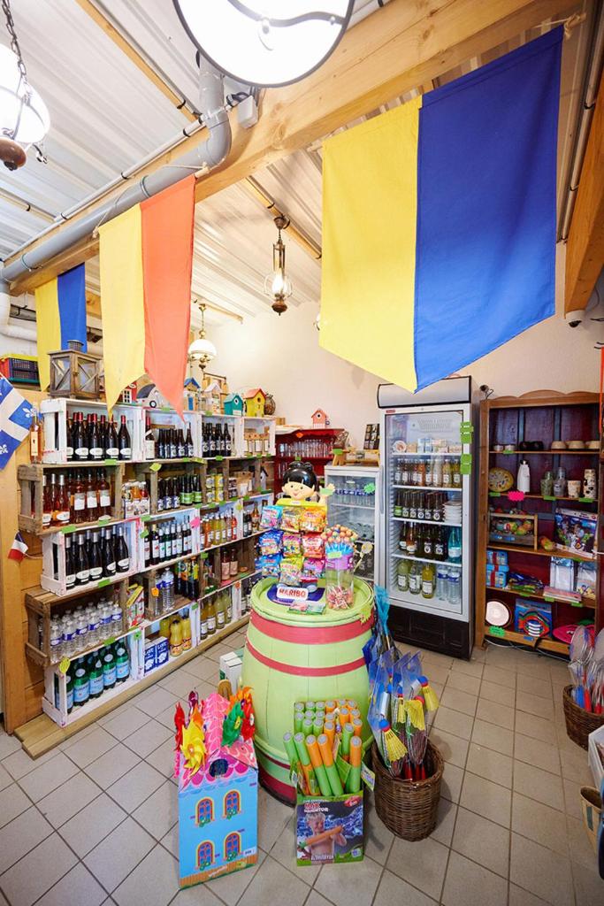 un magasin avec des drapeaux colorés suspendus au plafond dans l'établissement Glamping Ornans, à Ornans 26 autres photos