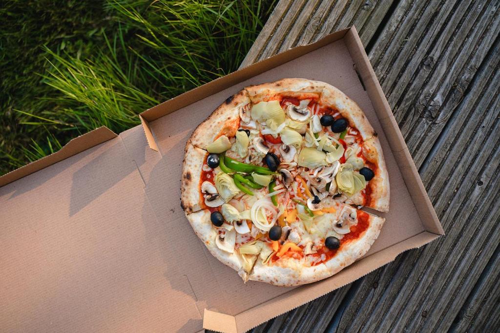 une pizza dans une boîte assise sur une table dans l'établissement Glamping the Vosges, à Corcieux