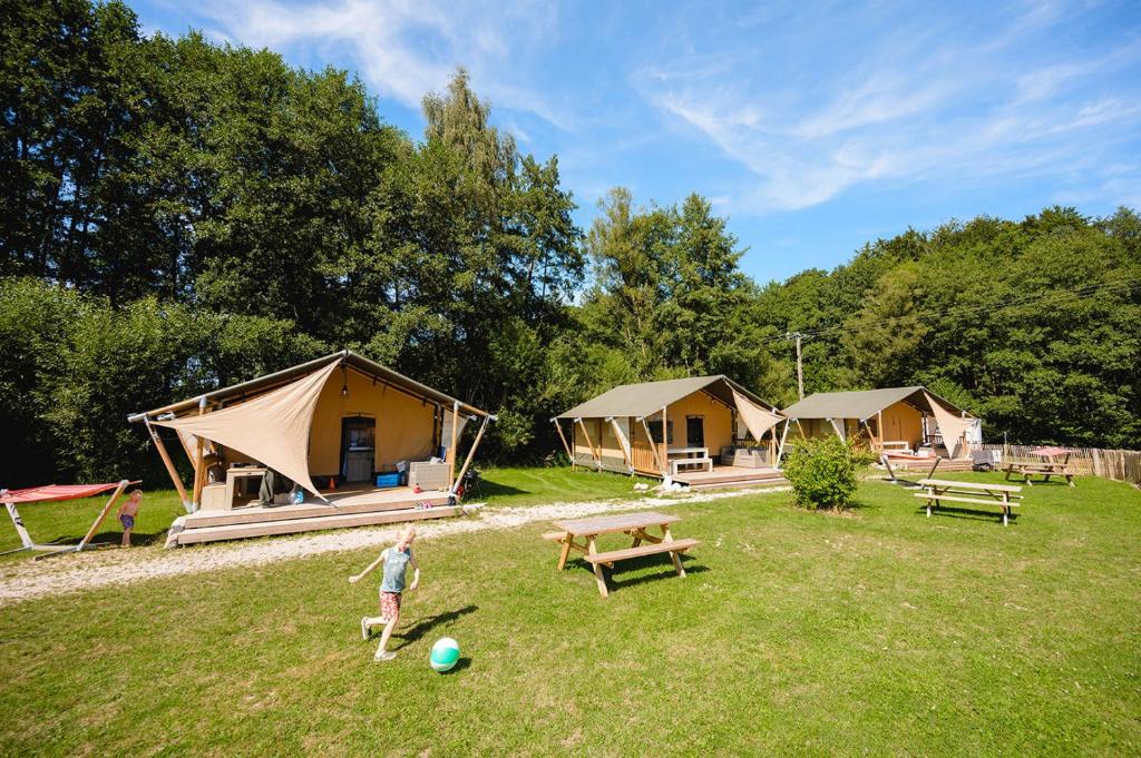 une personne jouant avec un ballon devant certaines tentes dans l'établissement Glamping the Vosges, à Corcieux