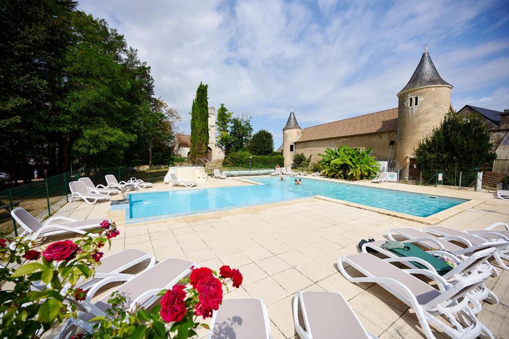 une piscine avec des chaises blanches et un bâtiment dans l'établissement Glamping Loire Valley, à Ingrandes