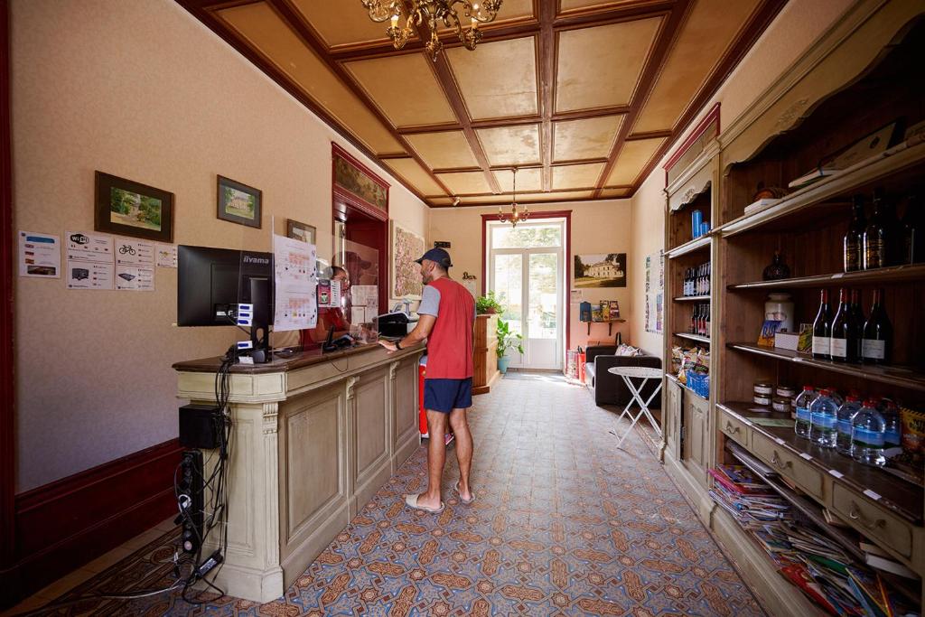un homme debout à un comptoir dans un bar dans l'établissement Glamping Loire Valley, à Ingrandes