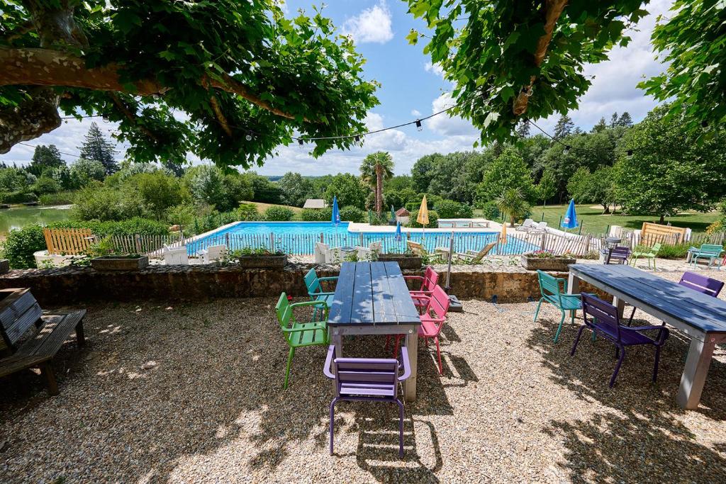 - un groupe de tables et de chaises à côté d'une piscine dans l'établissement Glamping Dordogne, à Douville