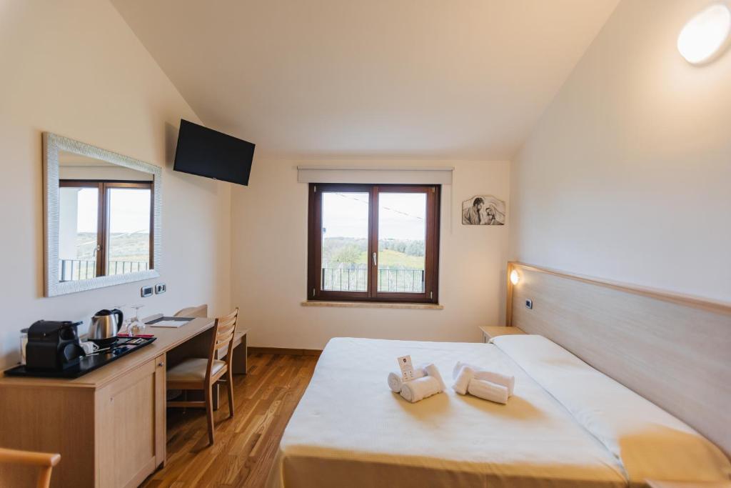 une chambre avec un lit, un bureau et une table dans l'établissement Magnificat Hotel&Resort, à Canosa Sannita