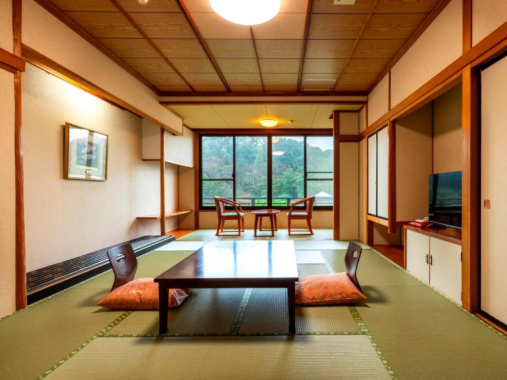 une salle à manger avec une table et des chaises dans une pièce dans l'établissement Hotel Sunvalley Izunagaoka Main Building, à Izunokuni 37 autres photos