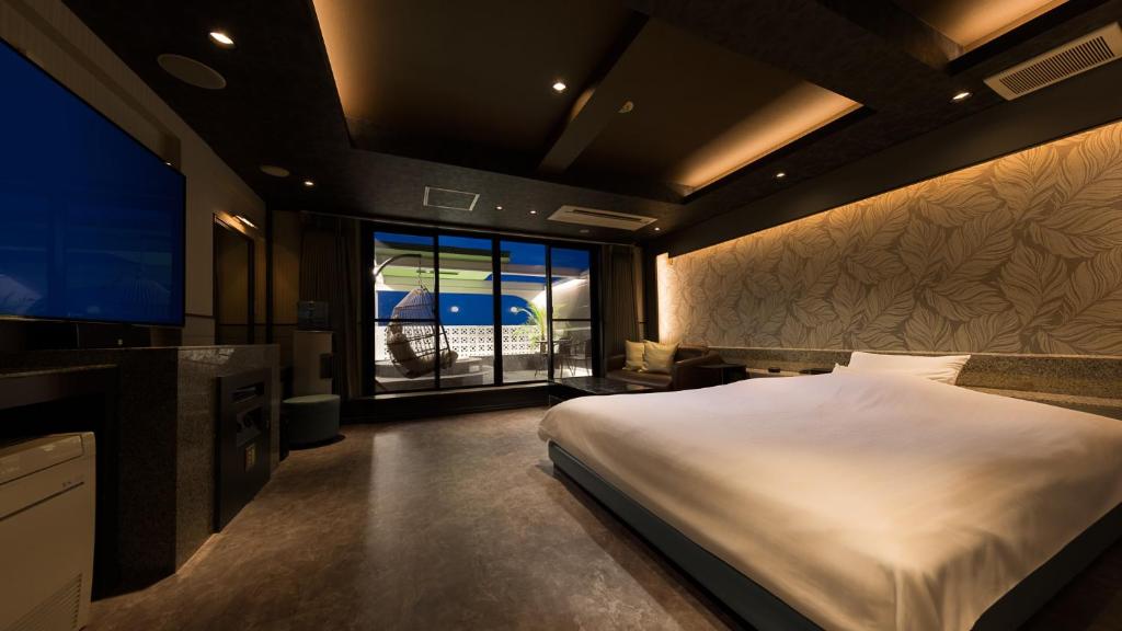 une chambre avec un grand lit et une grande fenêtre dans l'établissement Hotel Crespa, à Shizuoka