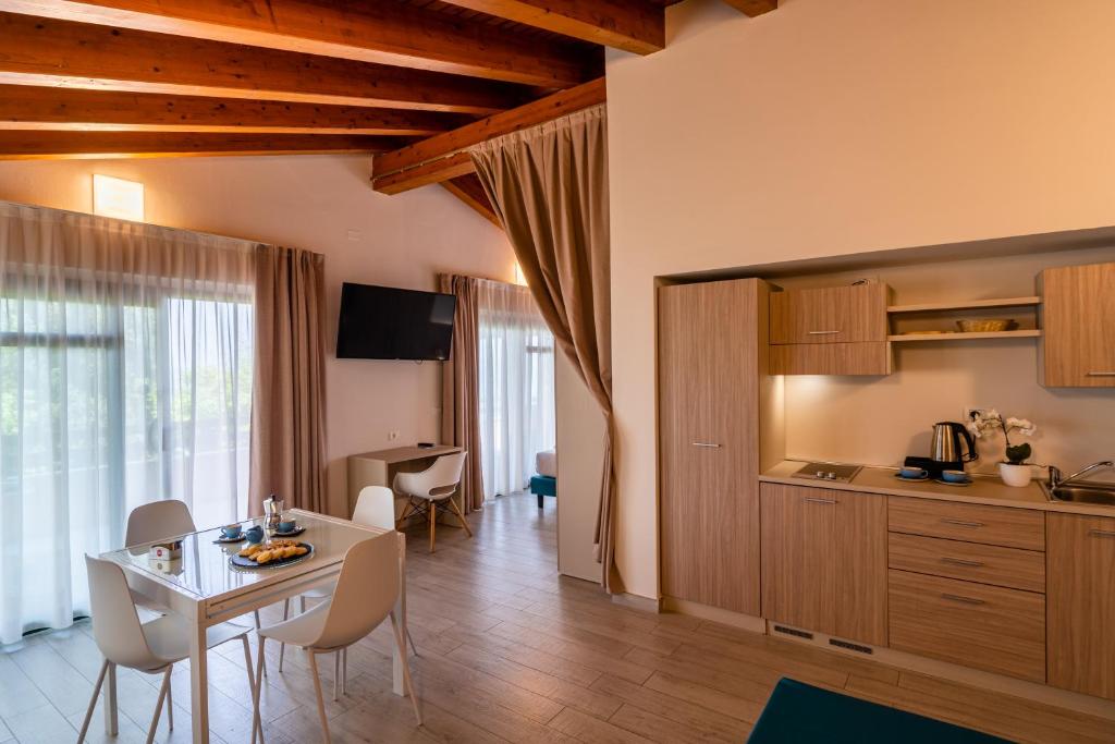 une cuisine et une salle à manger avec une table et des chaises dans l'établissement Club del Sole Desenzano Boutique Resort, à Desenzano del Garda