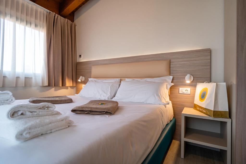 une chambre avec un lit avec des serviettes dessus dans l'établissement Club del Sole Desenzano Boutique Resort, à Desenzano del Garda 77 autres photos
