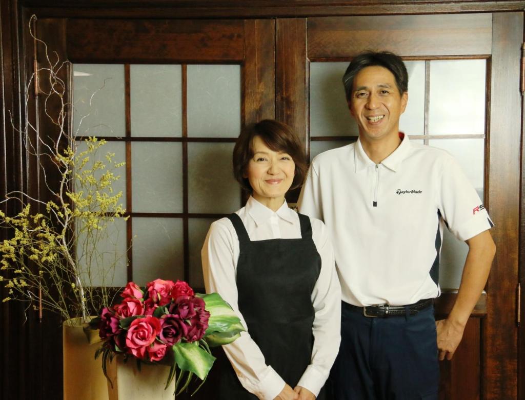 un homme et une femme debout à côté d'un bouquet de roses dans l'établissement Hakuba Tsugaike Sunrise Tanne, à Otari 33 autres photos