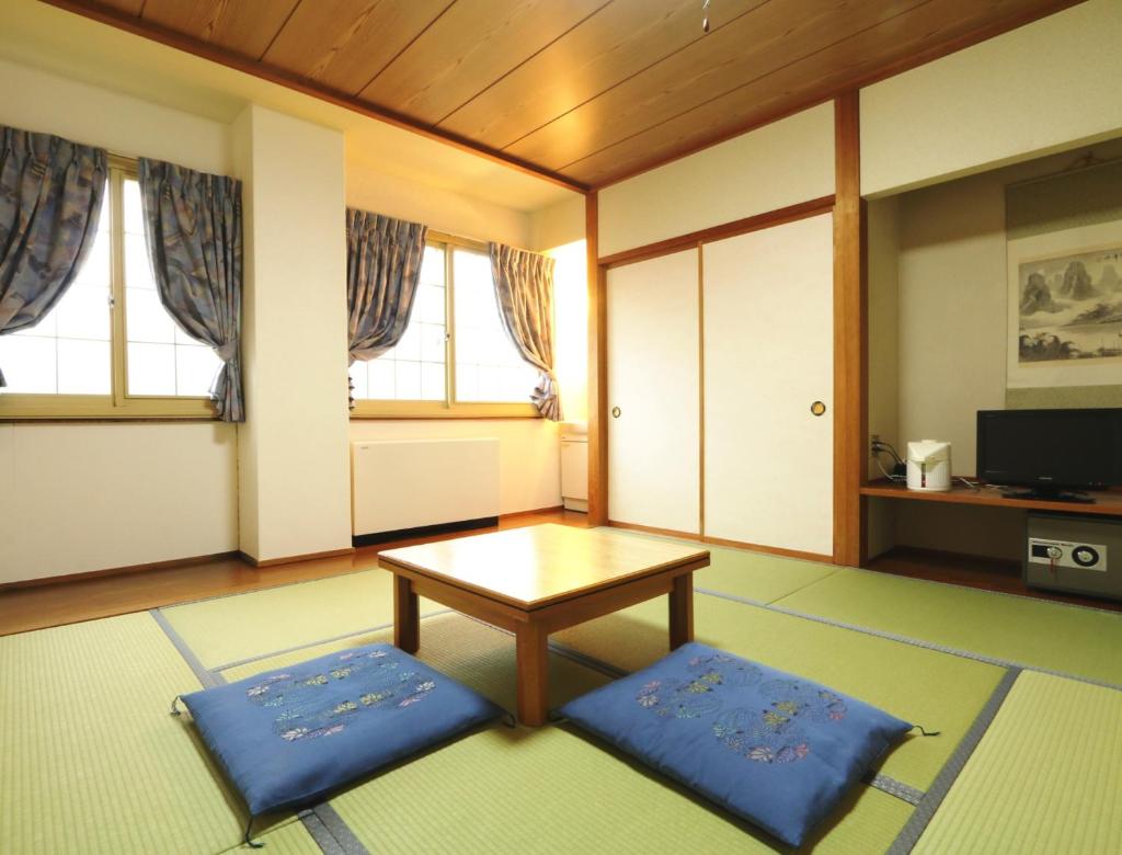 - un salon avec une table basse et des tapis bleus dans l'établissement Hakuba Tsugaike Sunrise Tanne, à Otari