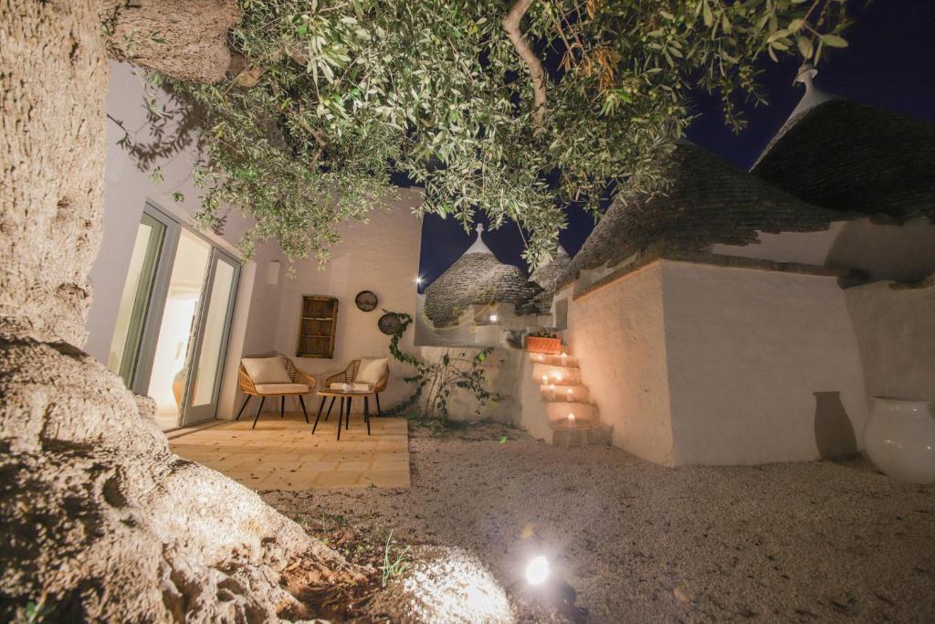 une chambre avec une table, des chaises et un arbre dans l'établissement TD Marlù Luxury Trulli Experience with Stunning Pool, à Castellana Grotte