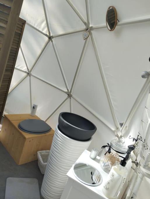La salle de bains est pourvue de toilettes et d'un mur blanc. dans l'établissement Dôme de l'Arriou, à Ourde