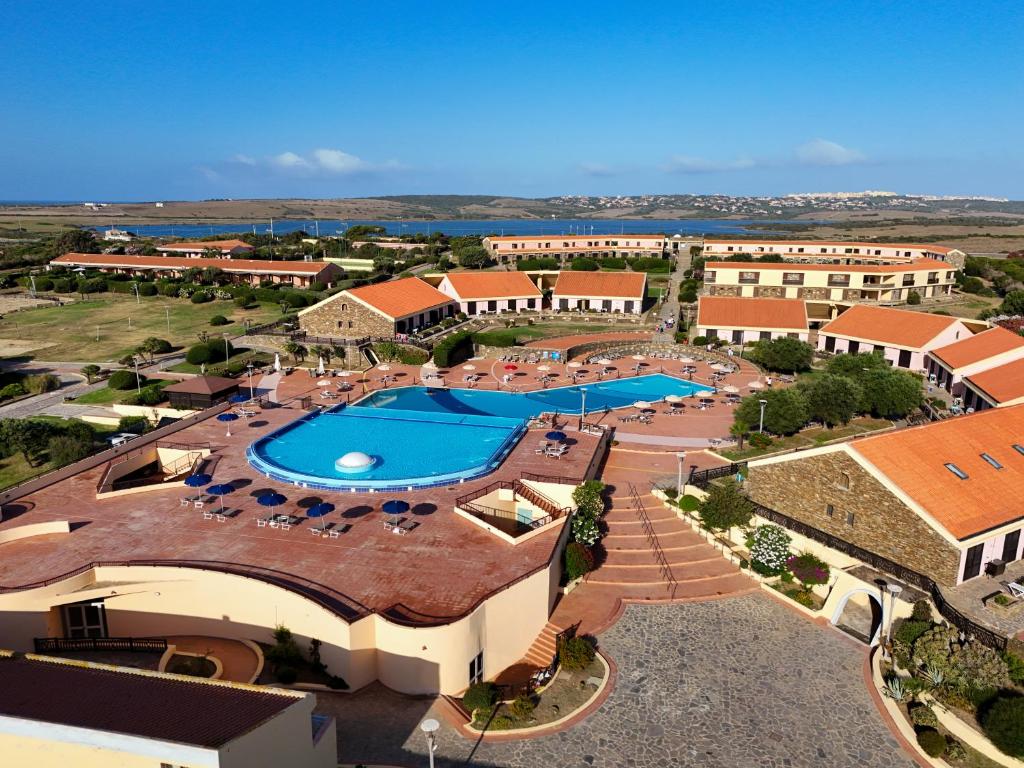 une vue aérienne d'un complexe hôtelier avec piscine dans l'établissement Le Tonnare di Stintino - Beach Resort, à Stintino
