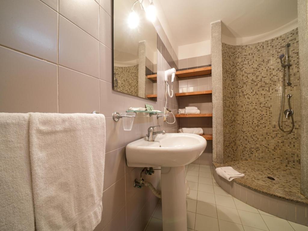 une salle de bain blanche avec lavabo et douche dans l'établissement Le Tonnare di Stintino - Beach Resort, à Stintino