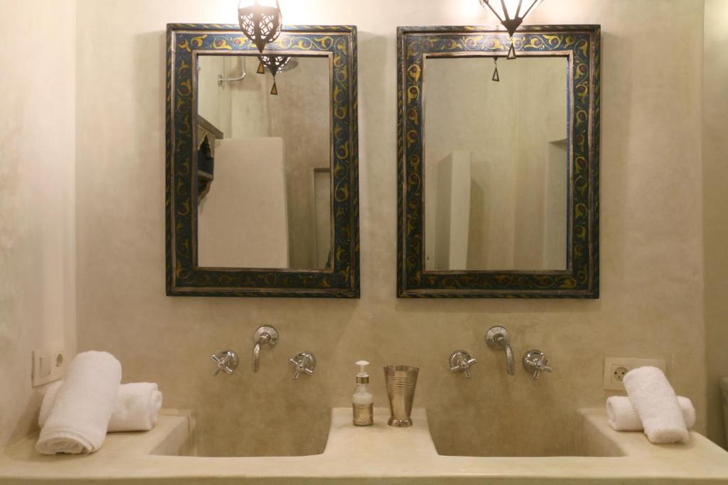 La salle de bains est pourvue de 2 lavabos, de miroirs et de serviettes. dans l'établissement Riad Dar Ayur, à Marrakech 21 autres photos