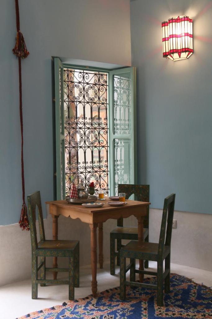 une salle à manger avec une table et des chaises et une fenêtre dans l'établissement Riad Dar Ayur, à Marrakech