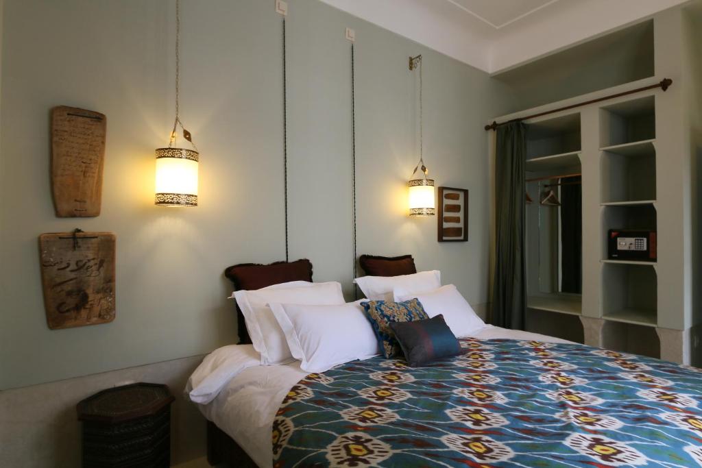 une chambre avec un lit avec des oreillers blancs dans l'établissement Riad Dar Ayur, à Marrakech
