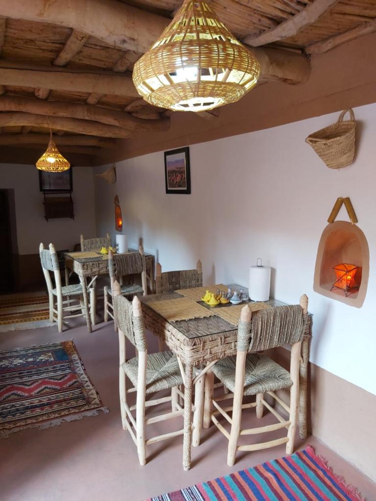 une salle à manger avec tables et chaises et un lustre dans l'établissement DAR DANI café restaurant, à Boumalne