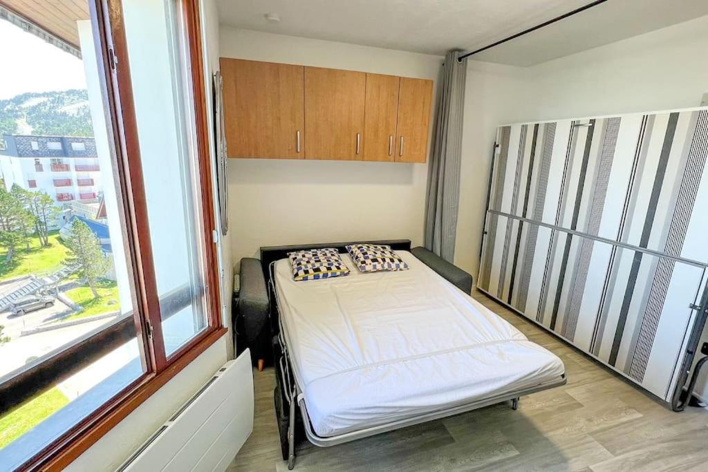 une chambre avec un lit dans une chambre avec une fenêtre dans l'établissement Cocon montagnard accès direct aux Pistes et GR10, à Arette