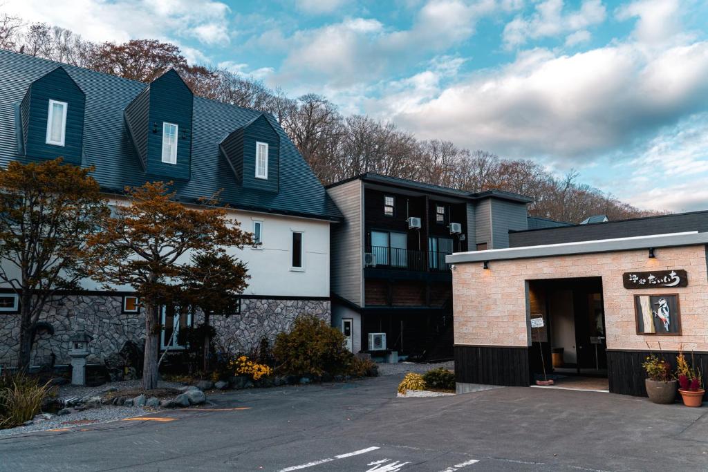 un bâtiment avec un parking devant dans l'établissement Yuyado DAIICHI, à Naka-shibetsu