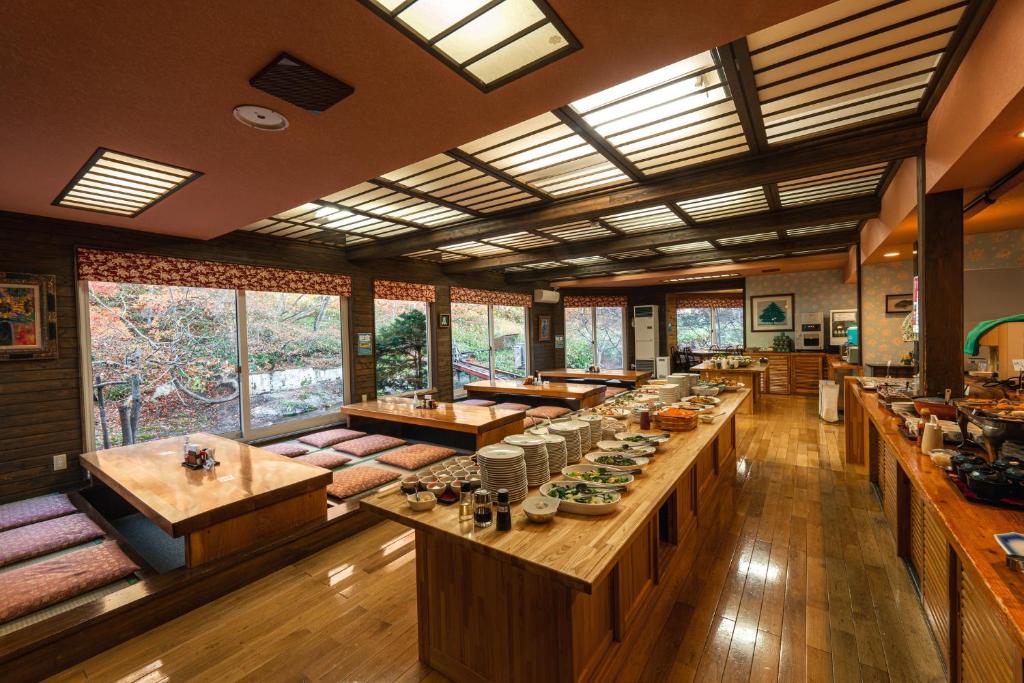 une grande pièce avec des tables, des bancs et des fenêtres dans l'établissement Yuyado DAIICHI, à Naka-shibetsu