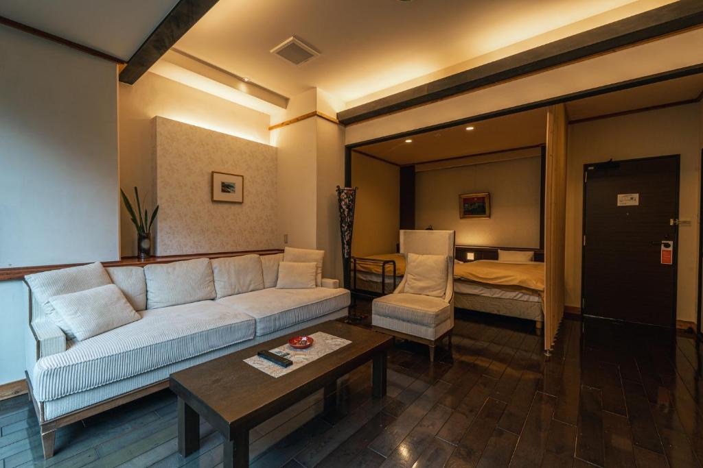 un salon avec un canapé et une chambre dans l'établissement Yuyado DAIICHI, à Naka-shibetsu 91 autres photos
