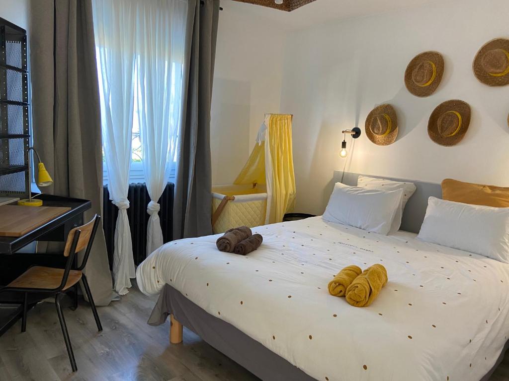 une chambre avec un grand lit avec des serviettes dessus dans l'établissement Les logis du forgeron, Gites de groupe entre Loire & vignes, à Saint-Jean-des-Mauvrets