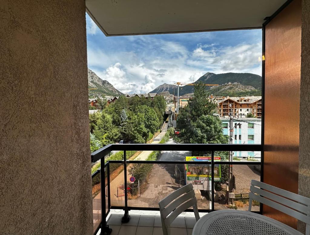 Elle comprend un balcon offrant une vue sur la ville et les montagnes. dans l'établissement Appartement Centre Ville pied de piste Briançon, à Briançon