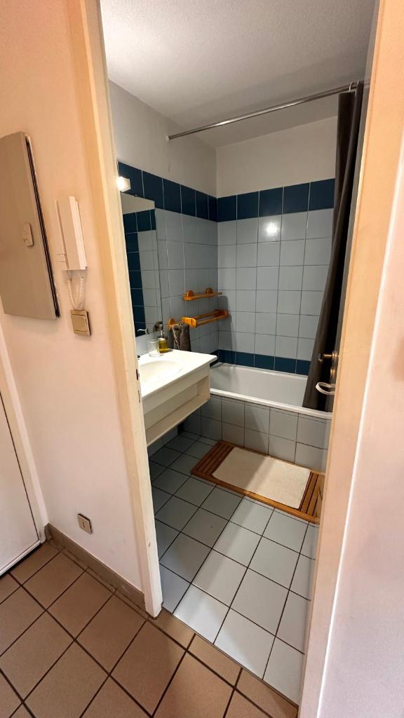 une salle de bain avec une baignoire et un lavabo dans l'établissement Appartement Centre Ville pied de piste Briançon, à Briançon 13 autres photos