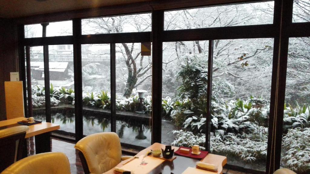 une pièce avec une table et une grande fenêtre dans l'établissement Hana No Shizuku, à Ureshino