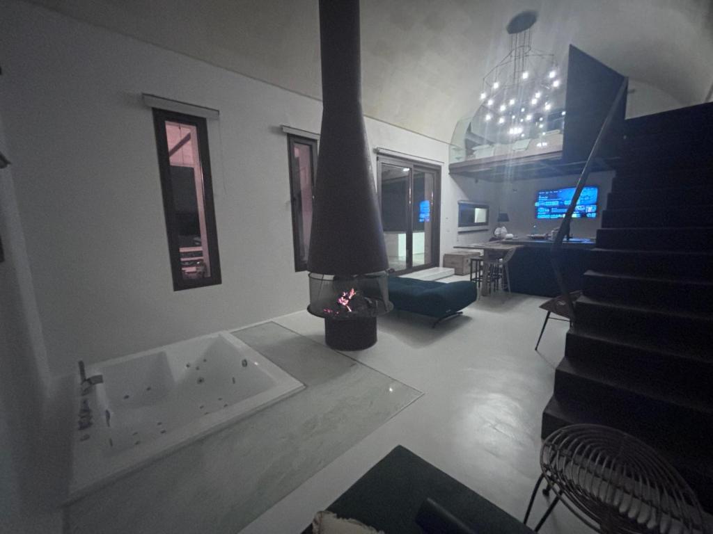 - un salon avec une cheminée au milieu d'une pièce dans l'établissement Aeneas Villa Pool & Jacuzzi al mare Torre Guaceto, à Specchiolla