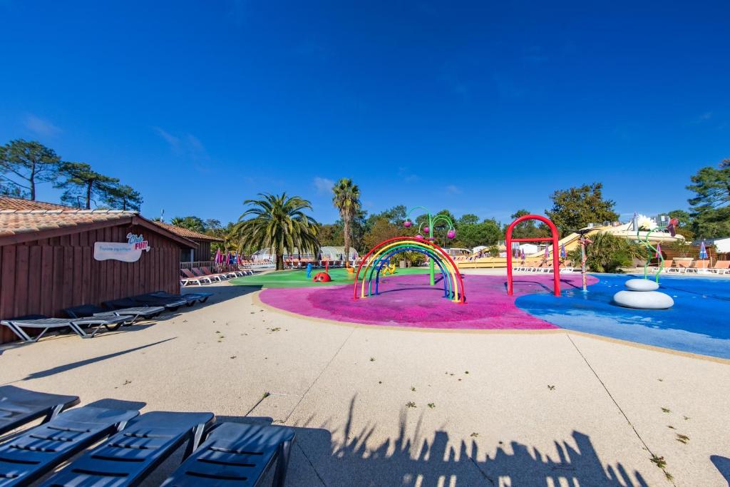 une piscine avec un toboggan et une aire de jeux dans l'établissement Mobil home Amira 42m2, à Lège-Cap-Ferret