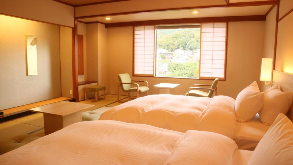 une chambre avec deux lits et une fenêtre dans l'établissement Hotel Gyokusen, à Matsue