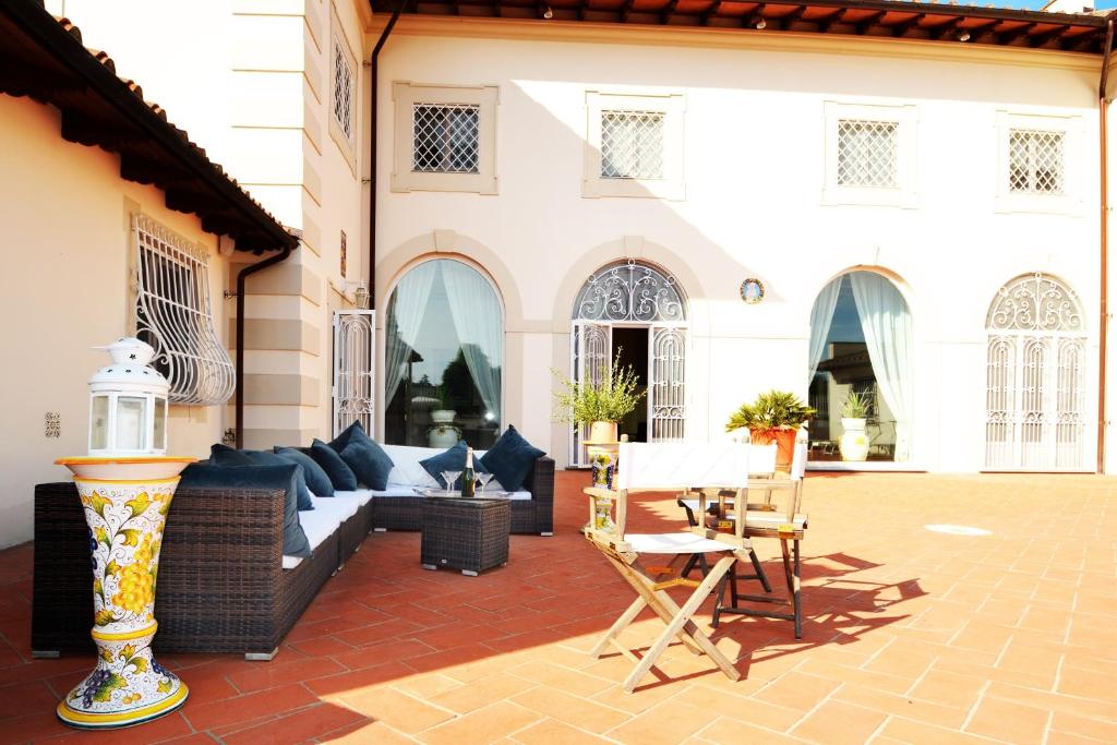 un patio avec un canapé, une table et des chaises dans l'établissement Villa Yvonne by MMega, à Signa