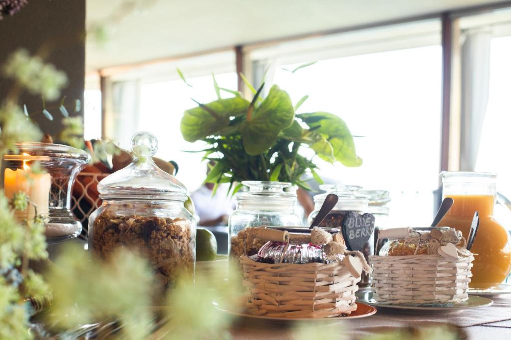 une table avec des bocaux et un panier de nourriture dans l'établissement Relais Villa Porta, à Luino