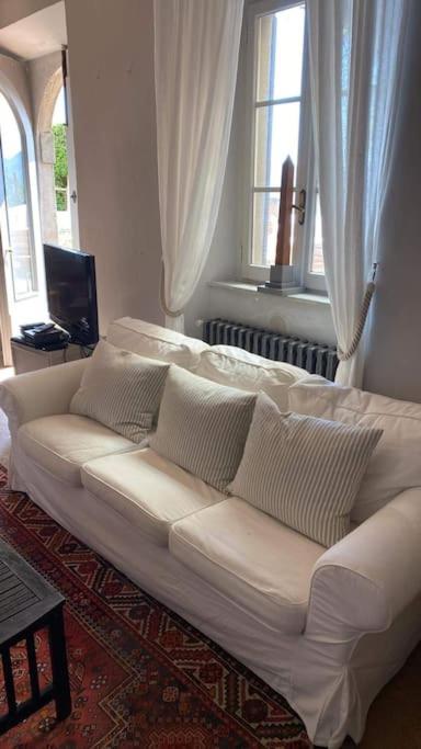 - un canapé blanc dans le salon doté de fenêtres dans l'établissement Beautiful Serena, à Coreglia Antelminelli