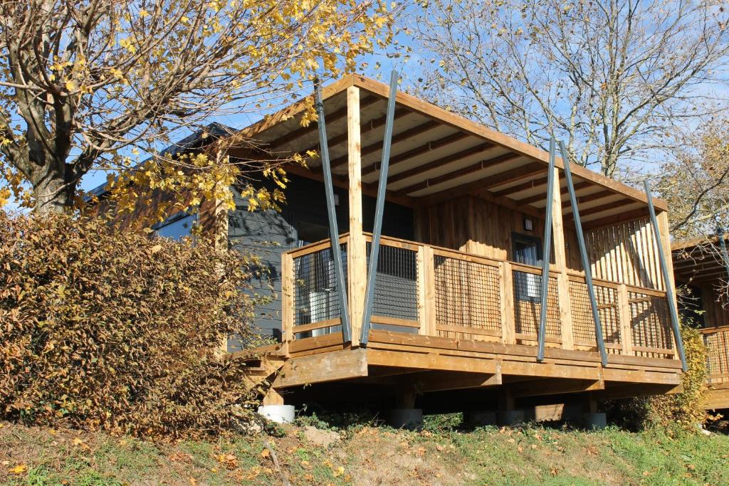 une maison avec terrasse sur une colline dans l'établissement Camping La Grappe Fleurie, à Fleurie