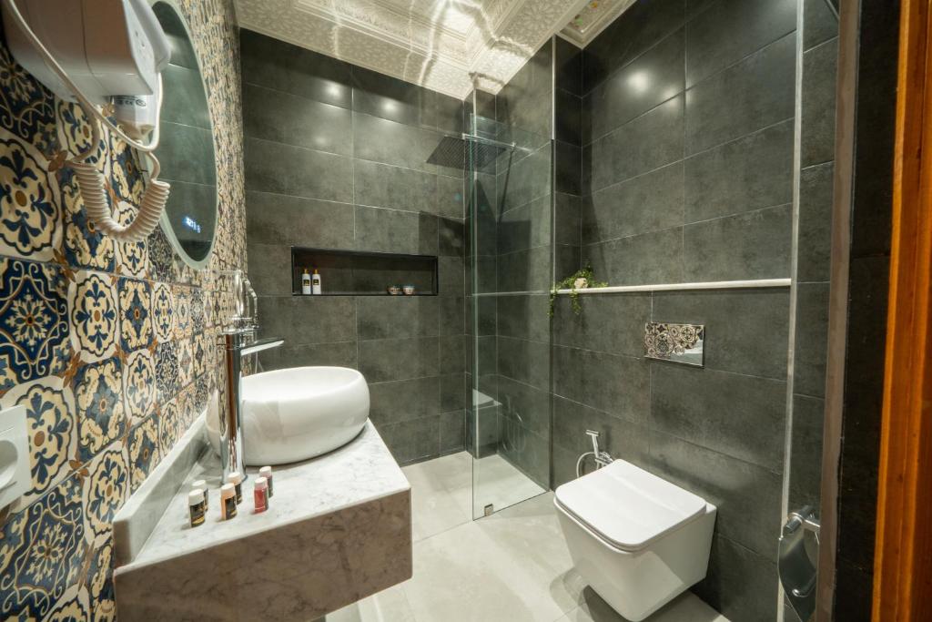 une salle de bain avec toilettes et douche en verre dans l'établissement Riad Nadalinn, à Marrakech 37 autres photos